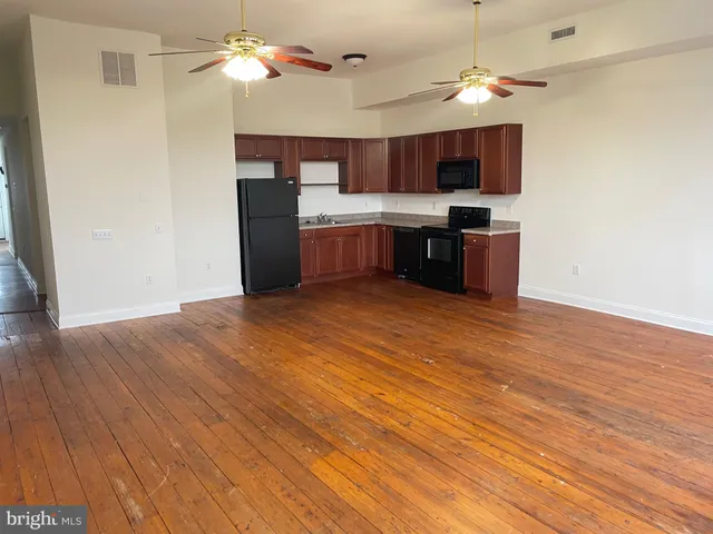 a kitchen with stainless steel appliances kitchen island a hardwood floor and a sink