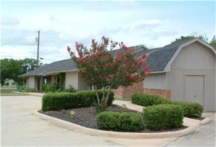 a front view of a house with a yard and potted plants