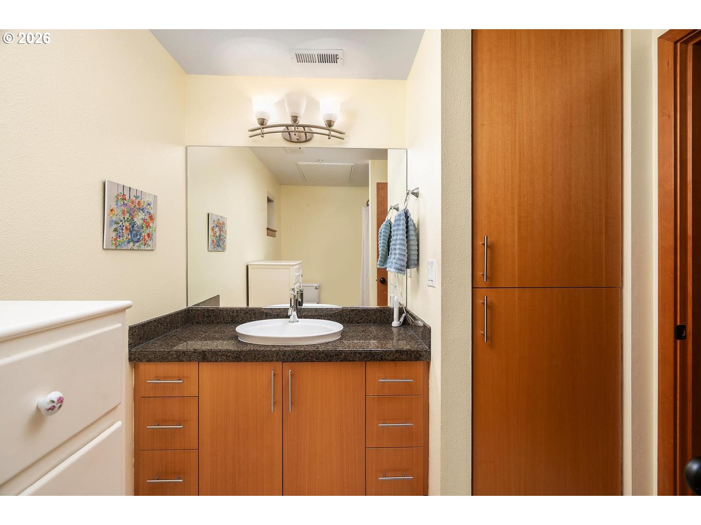 7910 Southwest 31st Avenue, Unit 203 Portland, OR 97219 - Photo 11 of 27 a bathroom with a granite countertop sink and a mirror