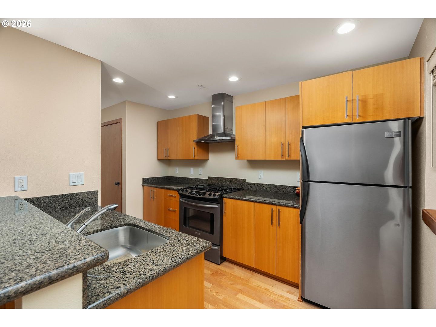 7910 Southwest 31st Avenue, Unit 203 Portland, OR 97219 - Photo 7 of 27 a kitchen with stainless steel appliances granite countertop a sink stove and refrigerator