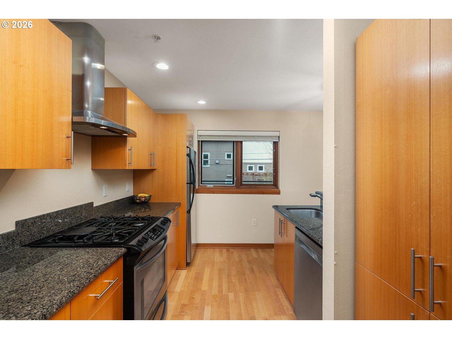 7910 Southwest 31st Avenue, Unit 203 Portland, OR 97219 - Photo 8 of 27 a kitchen with a stove a refrigerator and wooden cabinets