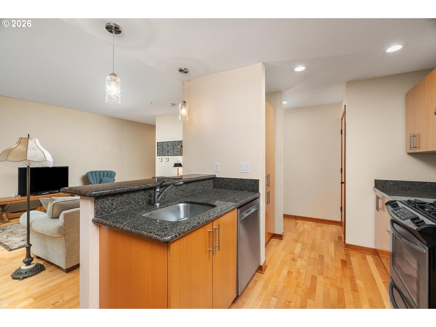 7910 Southwest 31st Avenue, Unit 203 Portland, OR 97219 - Photo 9 of 27 a kitchen with stainless steel appliances granite countertop a sink a refrigerator and a stove