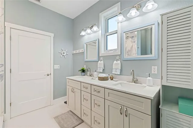 a bathroom with a sink a vanity a mirror and a bathtub next to a window