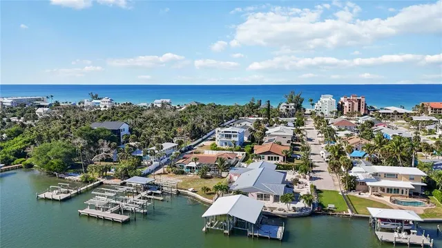 an aerial view of a city with lots of residential buildings ocean and mountain view in back