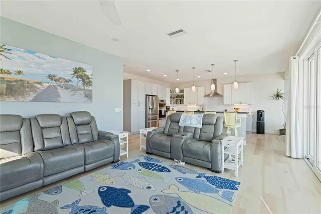 a living room with furniture and a view of kitchen
