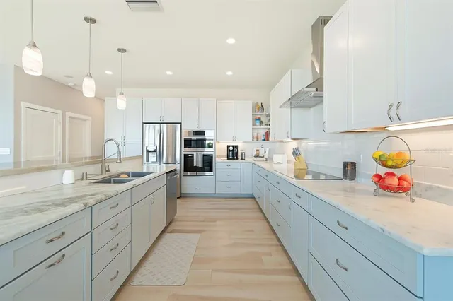 a large kitchen with kitchen island a sink stainless steel appliances and cabinets