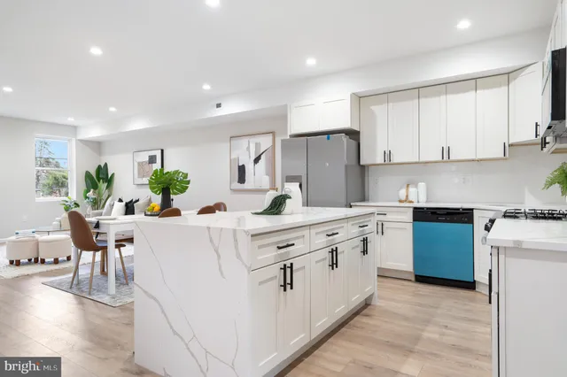 a kitchen with stainless steel appliances white cabinets sink and wooden floor
