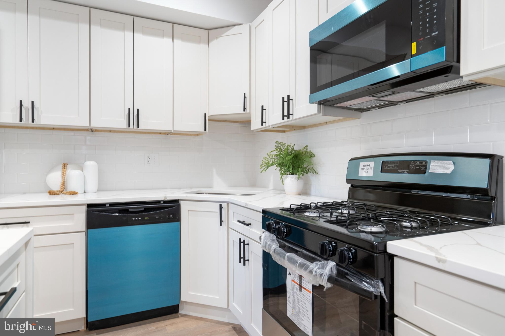 4011 Ridgewood Avenue Baltimore, MD 21215 - Photo 11 of 35 a kitchen with stainless steel appliances granite countertop white cabinets a stove a sink and dishwasher