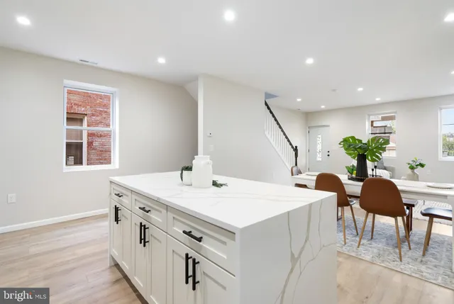 a view of kitchen with stainless steel appliances kitchen island a stove a table and chairs in it