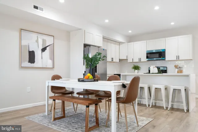 a kitchen with a table chairs refrigerator and microwave
