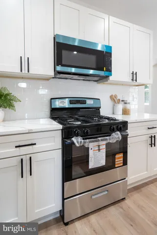 a kitchen with stainless steel appliances granite countertop a stove and a microwave