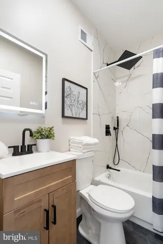 a bathroom with a sink toilet and a mirror