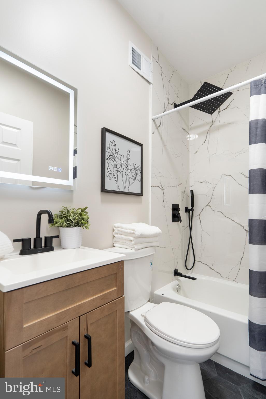 4011 Ridgewood Avenue Baltimore, MD 21215 - Photo 21 of 35 a bathroom with a sink toilet and a mirror
