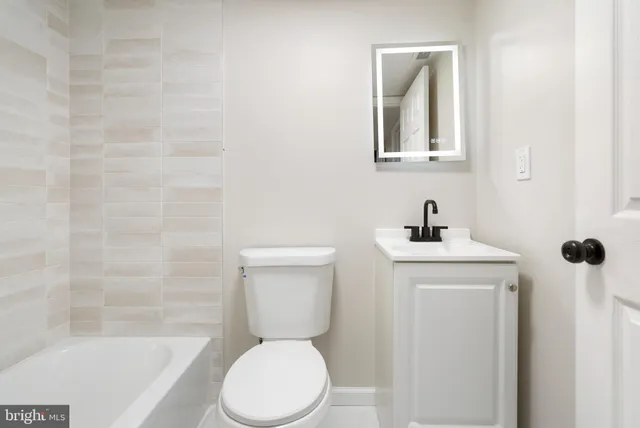 a white toilet sitting next to a bathroom sink