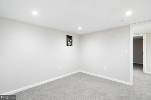 an empty room with a white wall and a window