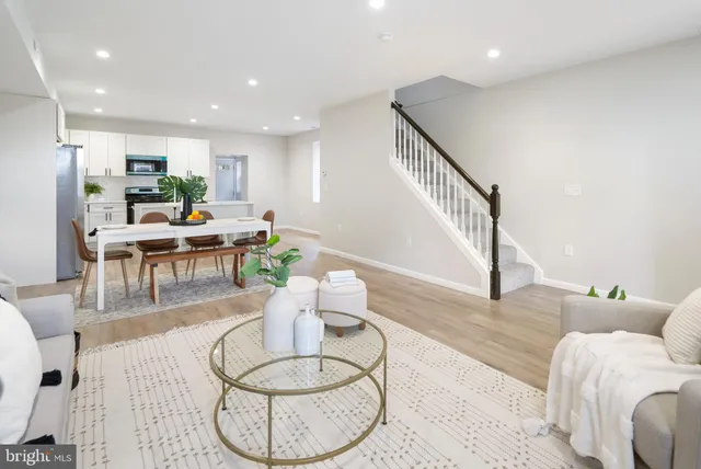 a living room with furniture and a dining table with wooden floor