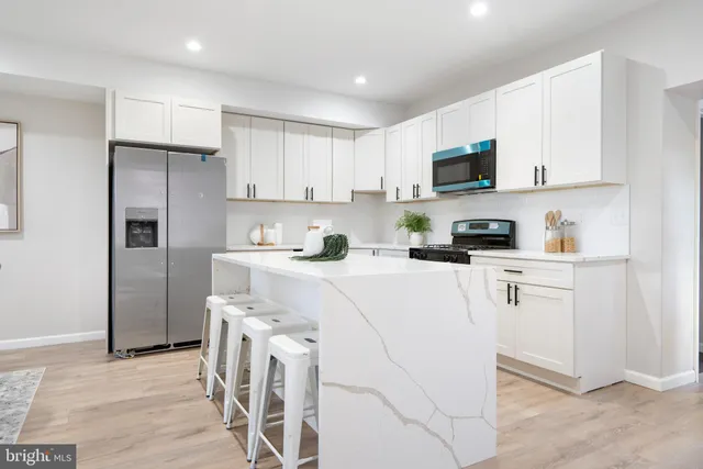 a kitchen with white cabinets and stainless steel appliances