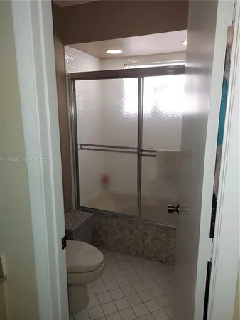 a bathroom with a granite countertop toilet and a shower