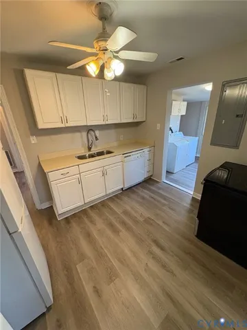 a kitchen with granite countertop a sink cabinets and wooden floor