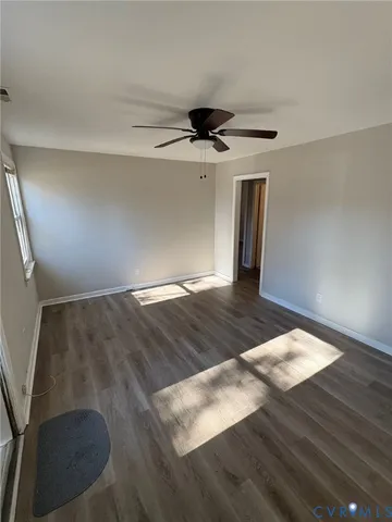 a view of a big room with wooden floor and windows