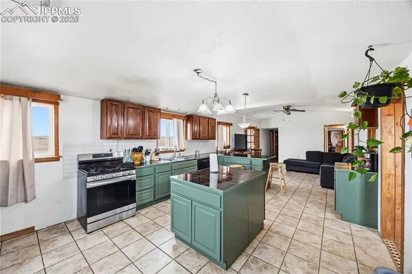 a kitchen with granite countertop a stove top oven and cabinets