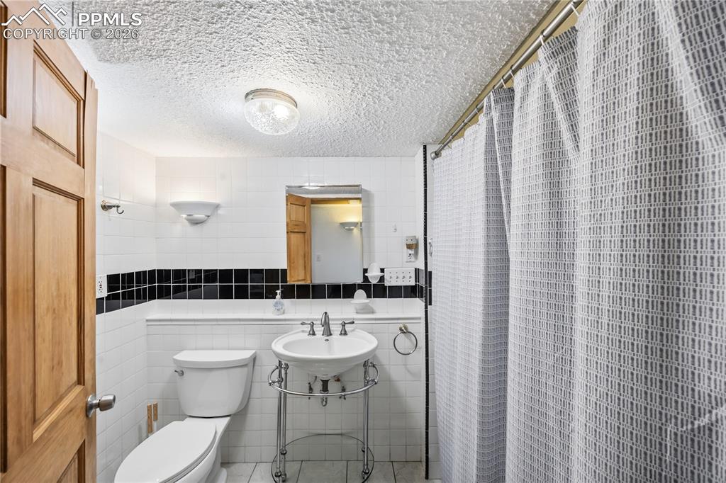 6615 Mulberry Road Calhan, CO 80808 - Photo 32 of 47 a bathroom with a sink a toilet a mirror and shower