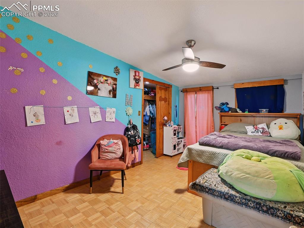 6615 Mulberry Road Calhan, CO 80808 - Photo 33 of 47 a bedroom with a bed and a chandelier