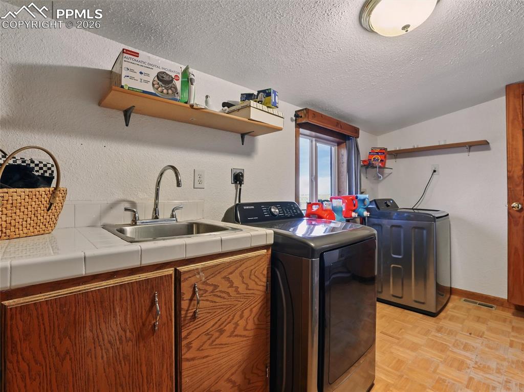 6615 Mulberry Road Calhan, CO 80808 - Photo 37 of 47 a utility room with cabinets a washer and dryer