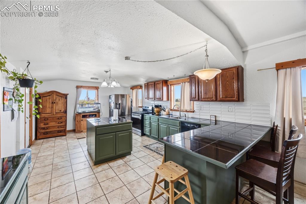 6615 Mulberry Road Calhan, CO 80808 - Photo 8 of 47 a kitchen with stainless steel appliances granite countertop a sink and a refrigerator