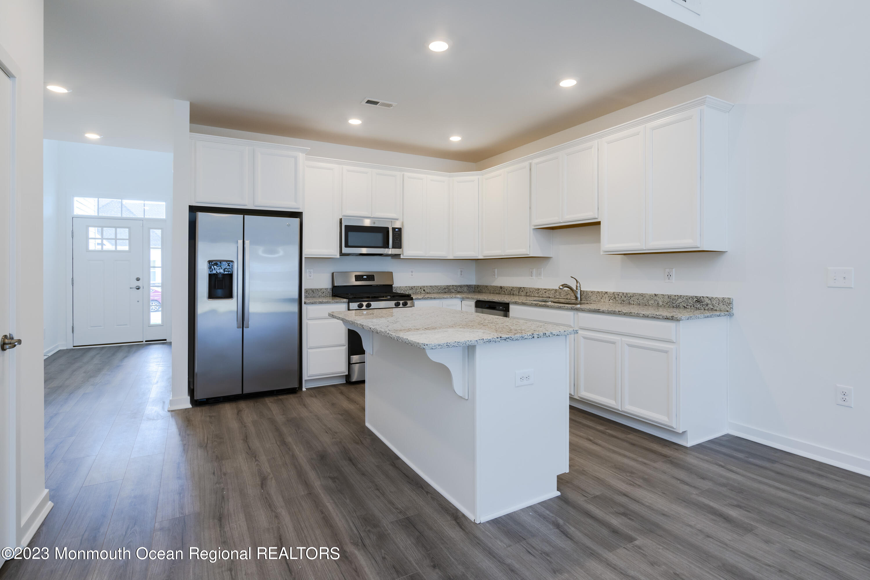 23 Gulfstream Road New Egypt, NJ 08533 - Photo 5 of 34 a kitchen with stainless steel appliances granite countertop a refrigerator a sink dishwasher a stove and white cabinets with wooden floor