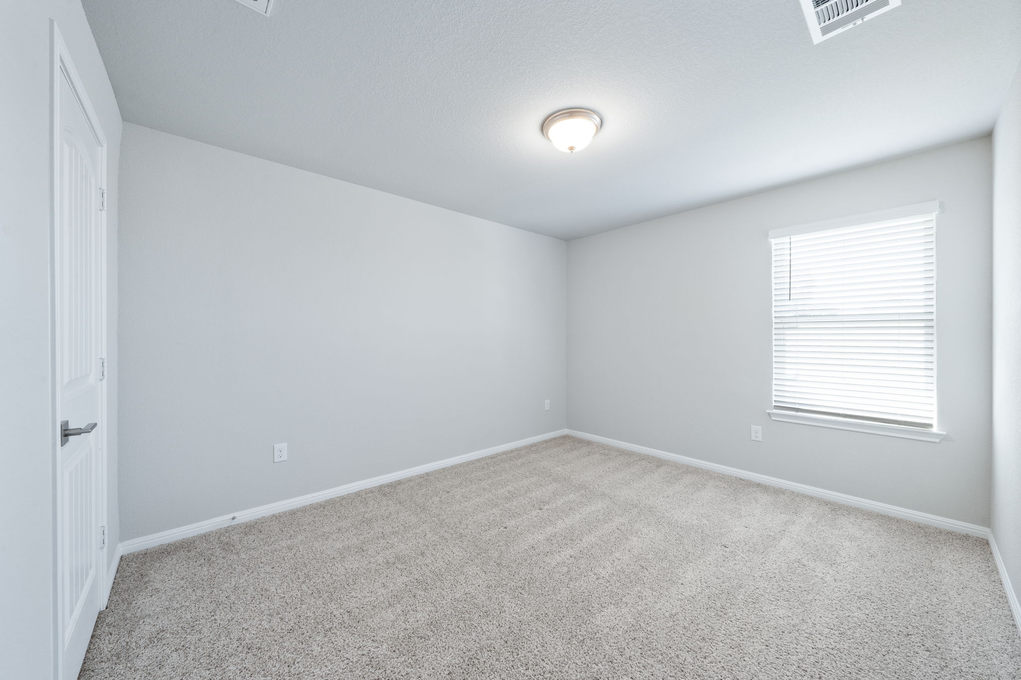 2412 Starhill Ranch Street Georgetown, TX 78628 - Photo 35 of 40 A well-proportioned bedroom with neutral carpet and a window offering ample illumination.