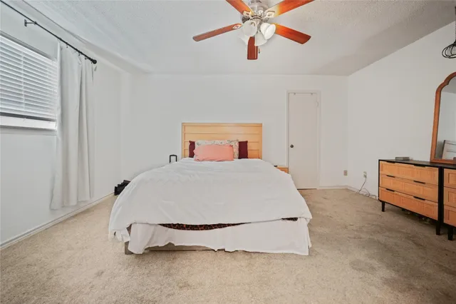 a spacious bedroom with a bed and a chandelier