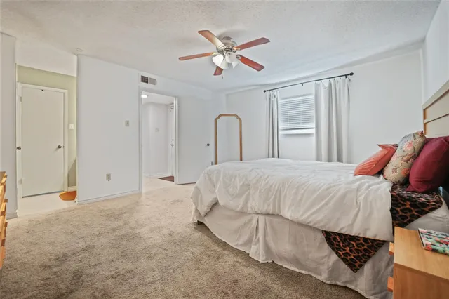 a bed room with a bed and a ceiling fan