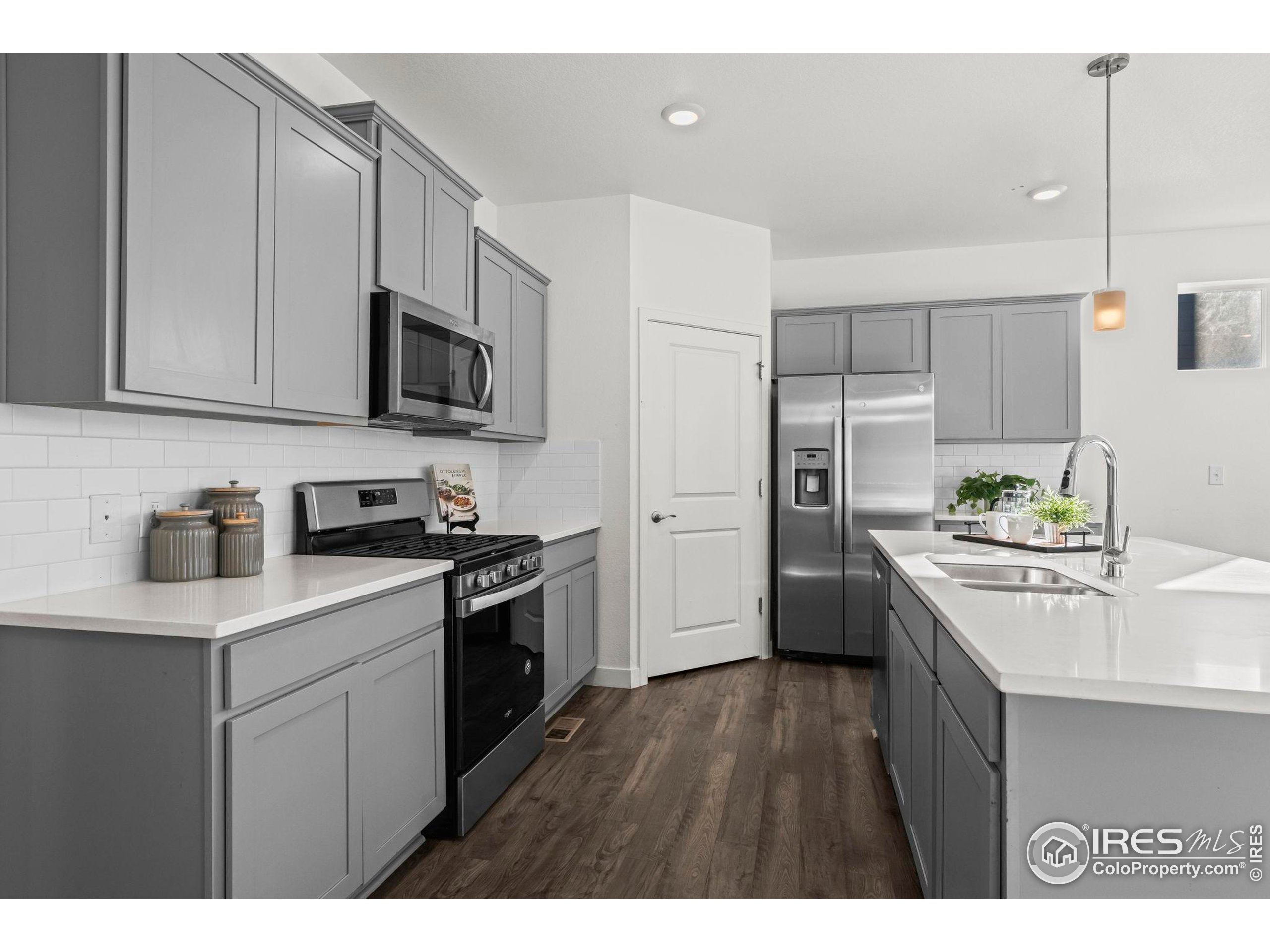 8957 Ferncrest Street Firestone, CO 80504 - Photo 16 of 50 a kitchen with stainless steel appliances granite countertop a sink stove and refrigerator