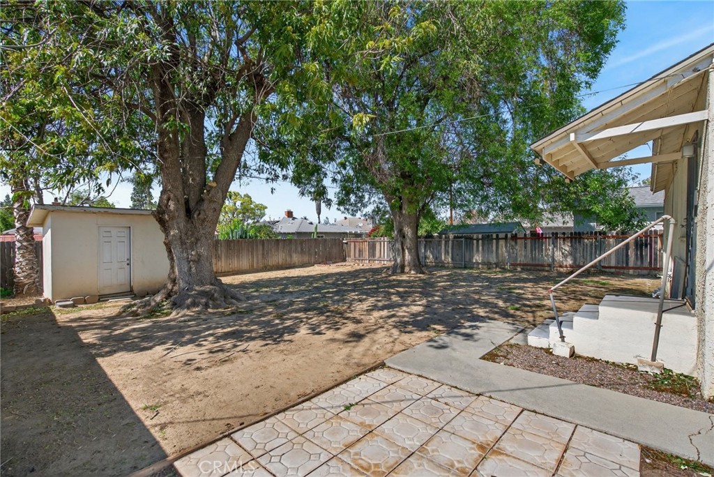 6845 Barcelona Way Riverside, CA 92504 - Photo 16 of 17 View of backyard from area behind the garage, which could be used for patio table and chairs, or a dog run.