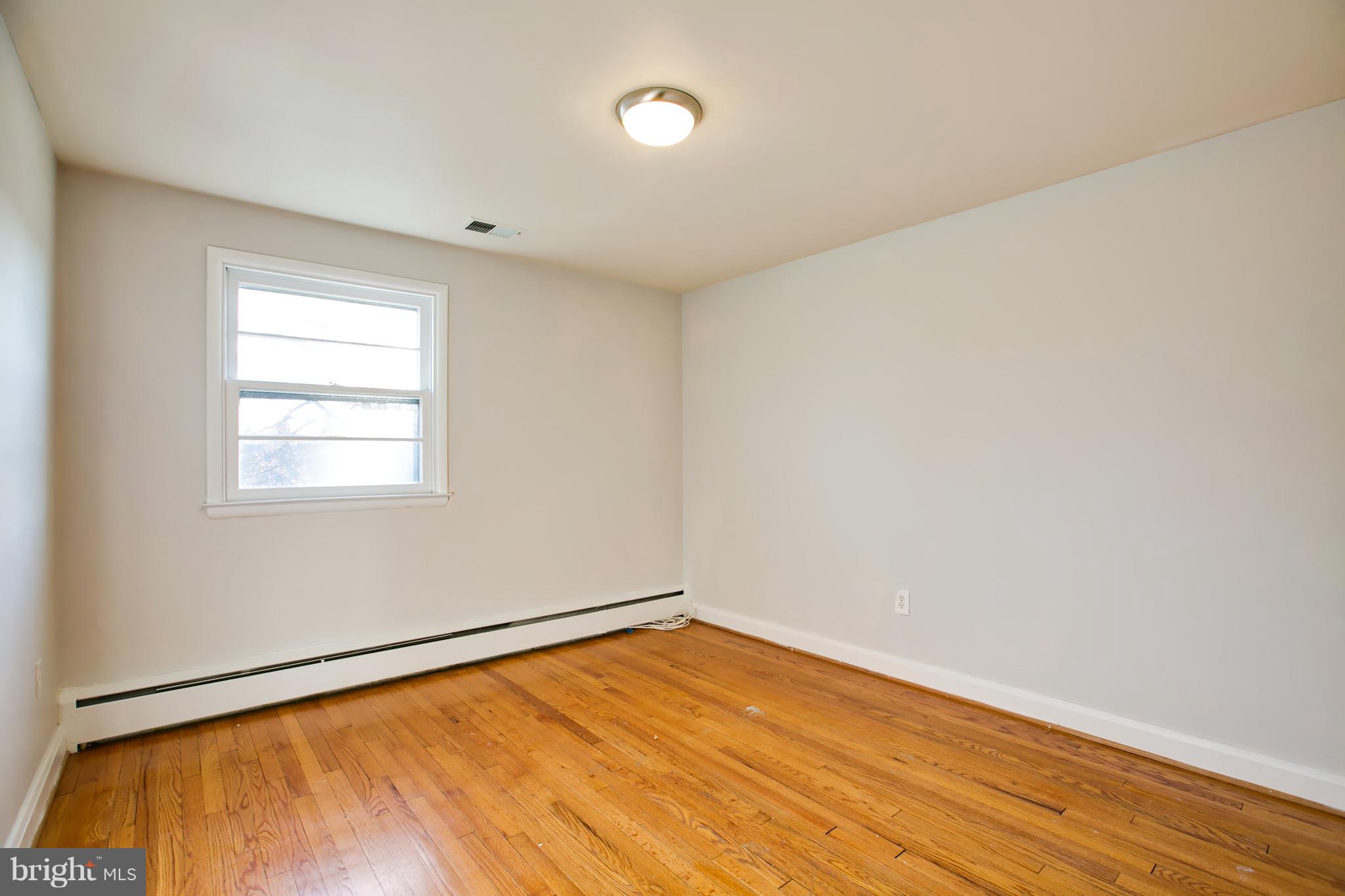 324 Aigburth Road Towson, MD 21286 - Photo 13 of 29 an empty room with wooden floor and windows