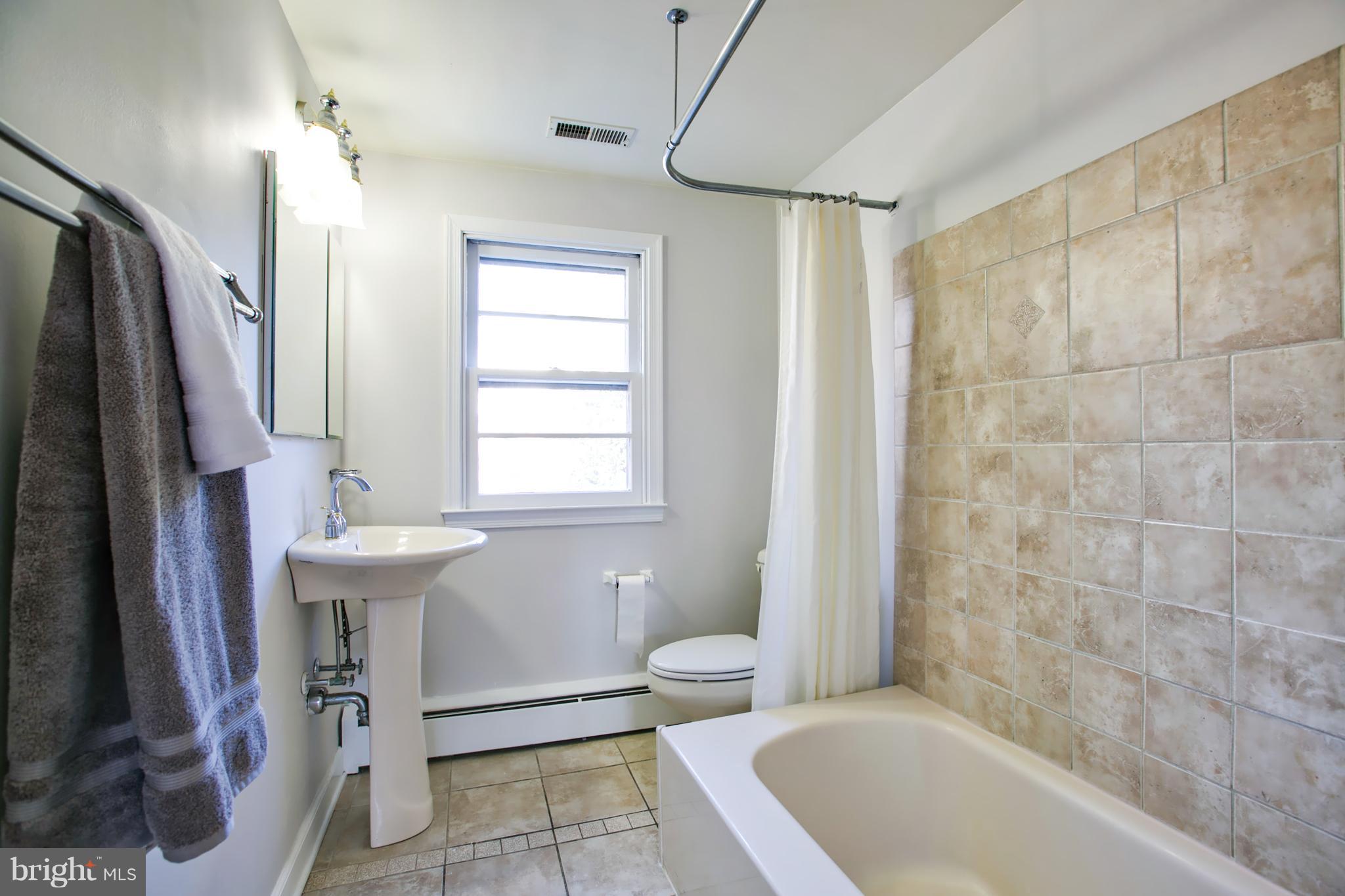 324 Aigburth Road Towson, MD 21286 - Photo 14 of 29 a bathroom with a sink a toilet a window and shower