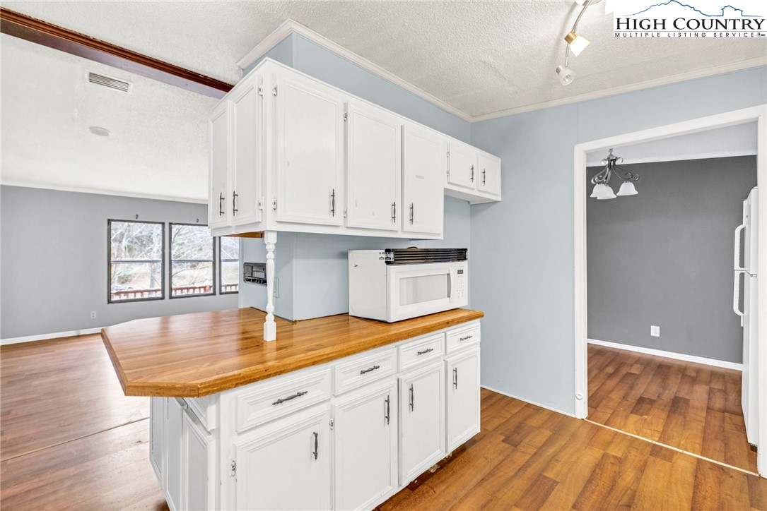 3303 Old Highway 16 Lansing, NC 28643 - Photo 13 of 30 a kitchen with stainless steel appliances granite countertop a sink dishwasher and cabinets with wooden floor
