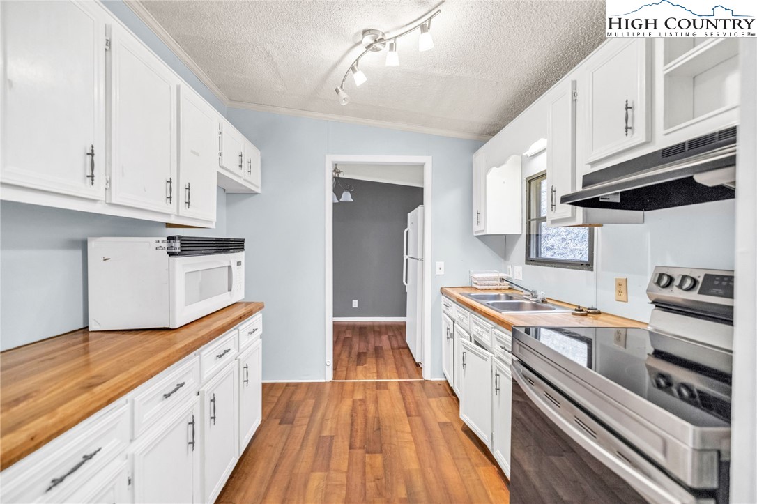 3303 Old Highway 16 Lansing, NC 28643 - Photo 14 of 30 a kitchen with white cabinets and appliances