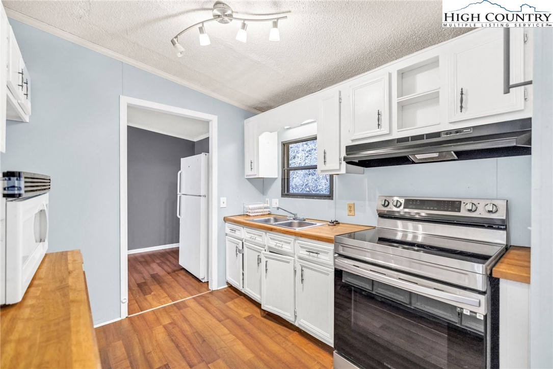 3303 Old Highway 16 Lansing, NC 28643 - Photo 15 of 30 a kitchen with stainless steel appliances a stove a sink and cabinets