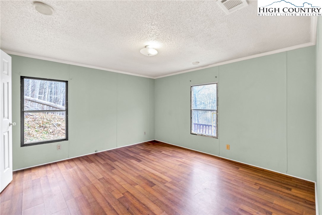 3303 Old Highway 16 Lansing, NC 28643 - Photo 19 of 30 wooden floor in an empty room with a window