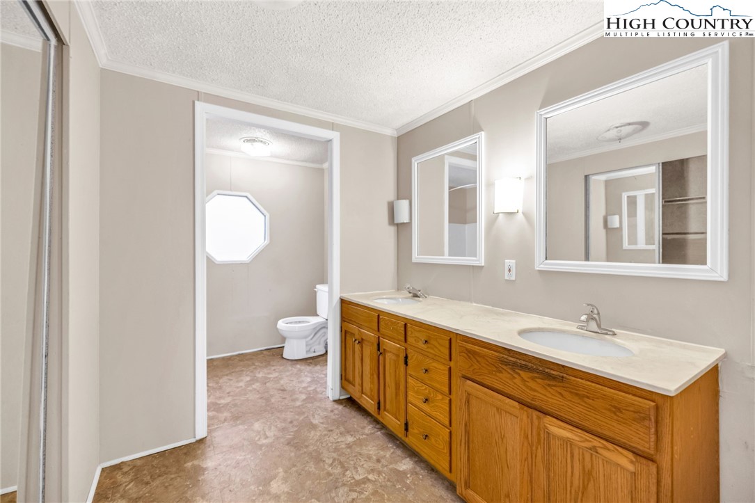 3303 Old Highway 16 Lansing, NC 28643 - Photo 21 of 30 a spacious bathroom with a double vanity sink toilet mirror and bathtub