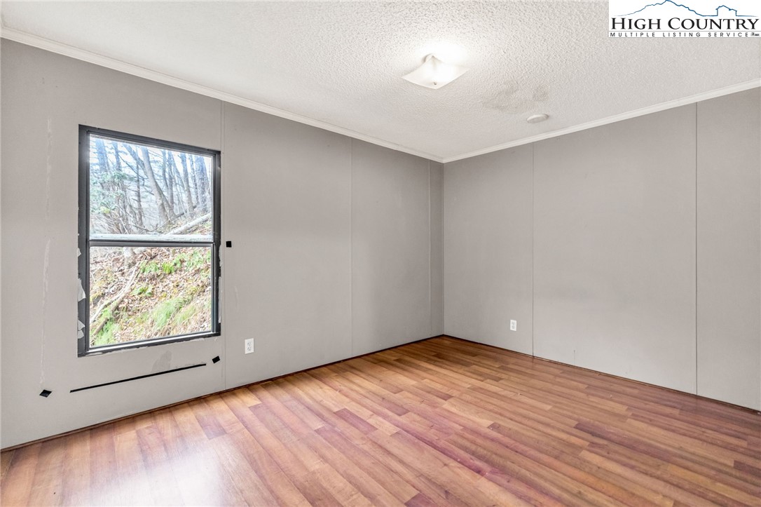 3303 Old Highway 16 Lansing, NC 28643 - Photo 27 of 30 an empty room with wooden floor and windows