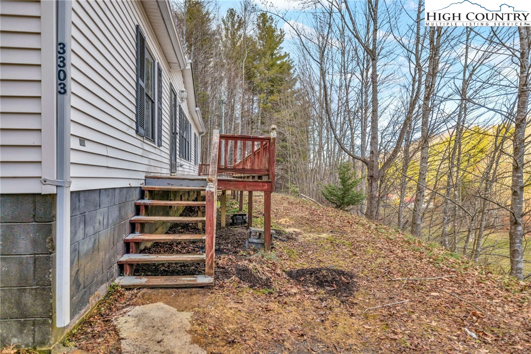3303 Old Highway 16 Lansing, NC 28643 - Photo 8 of 30 a backyard of a house with wooden fence and large trees