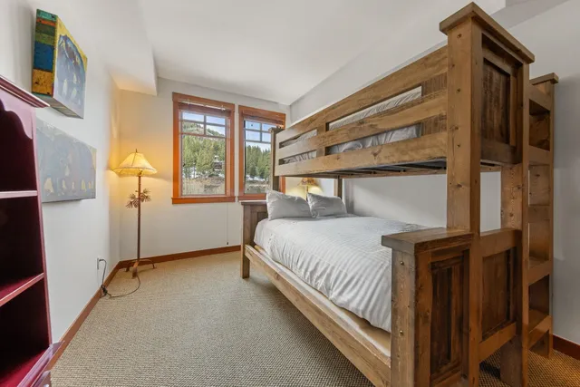 a bedroom with a bed and windows