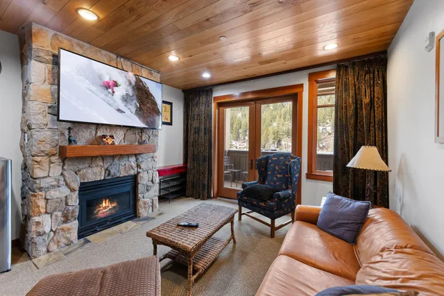 a living room with furniture a fireplace and a large window
