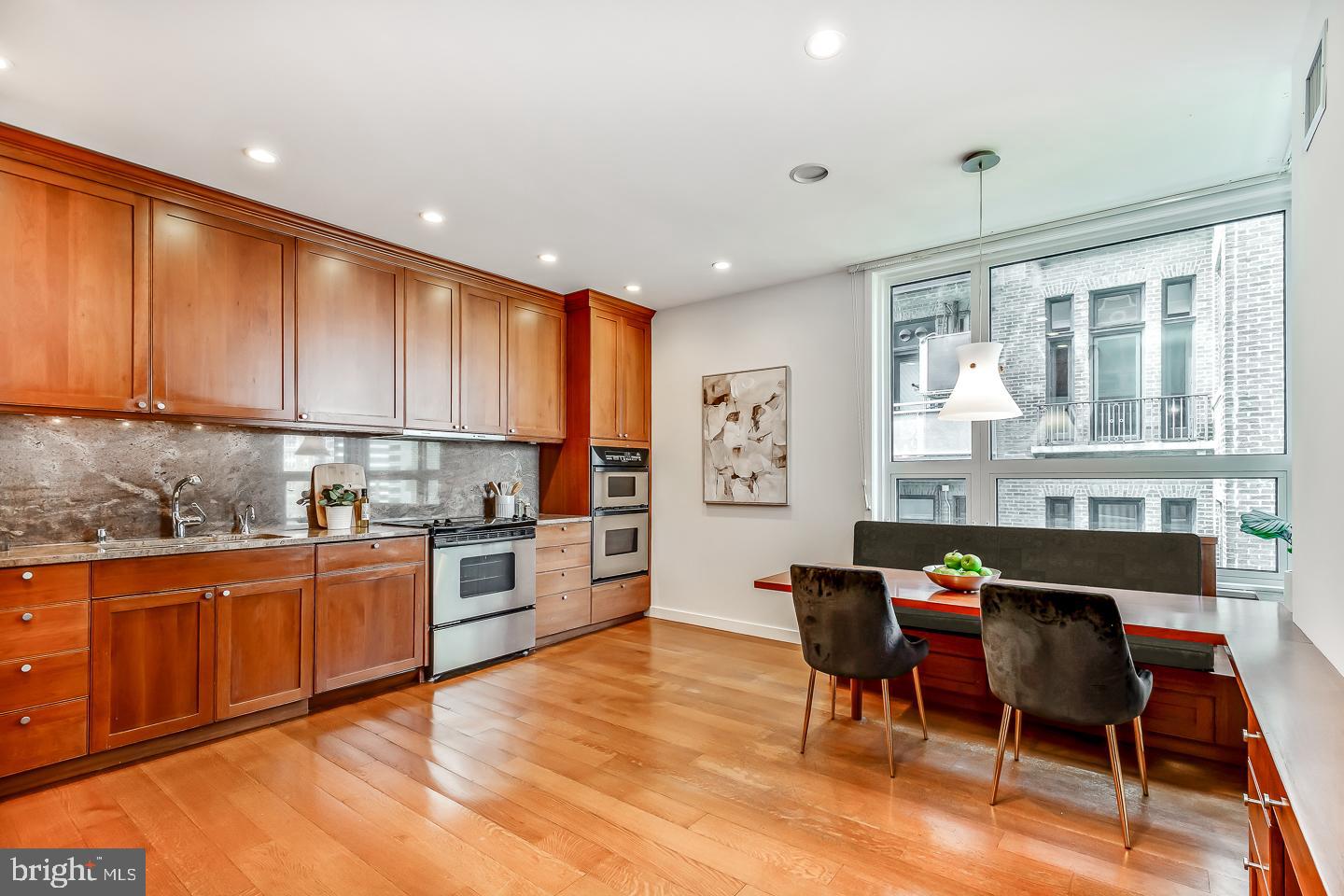 1820 Rittenhouse Square, Unit 1601 Philadelphia, PA 19103 - Photo 22 of 53 a kitchen with granite countertop a stove a sink a dining table and chairs