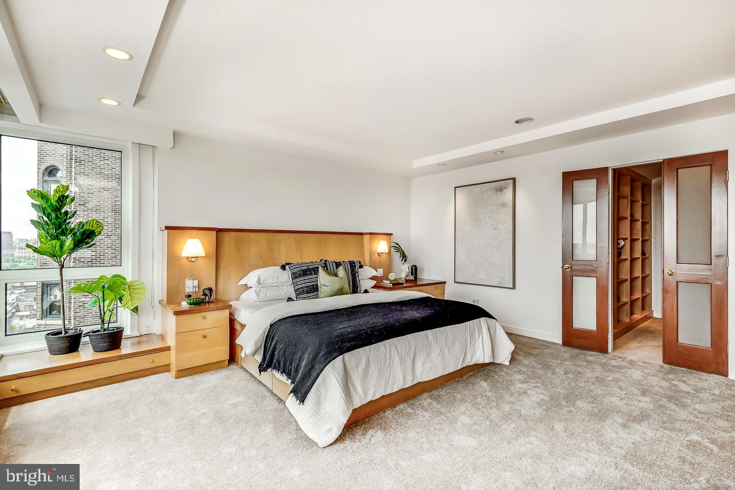 1820 Rittenhouse Square, Unit 1601 Philadelphia, PA 19103 - Photo 30 of 53 a bedroom with a bed and potted plant next to a window