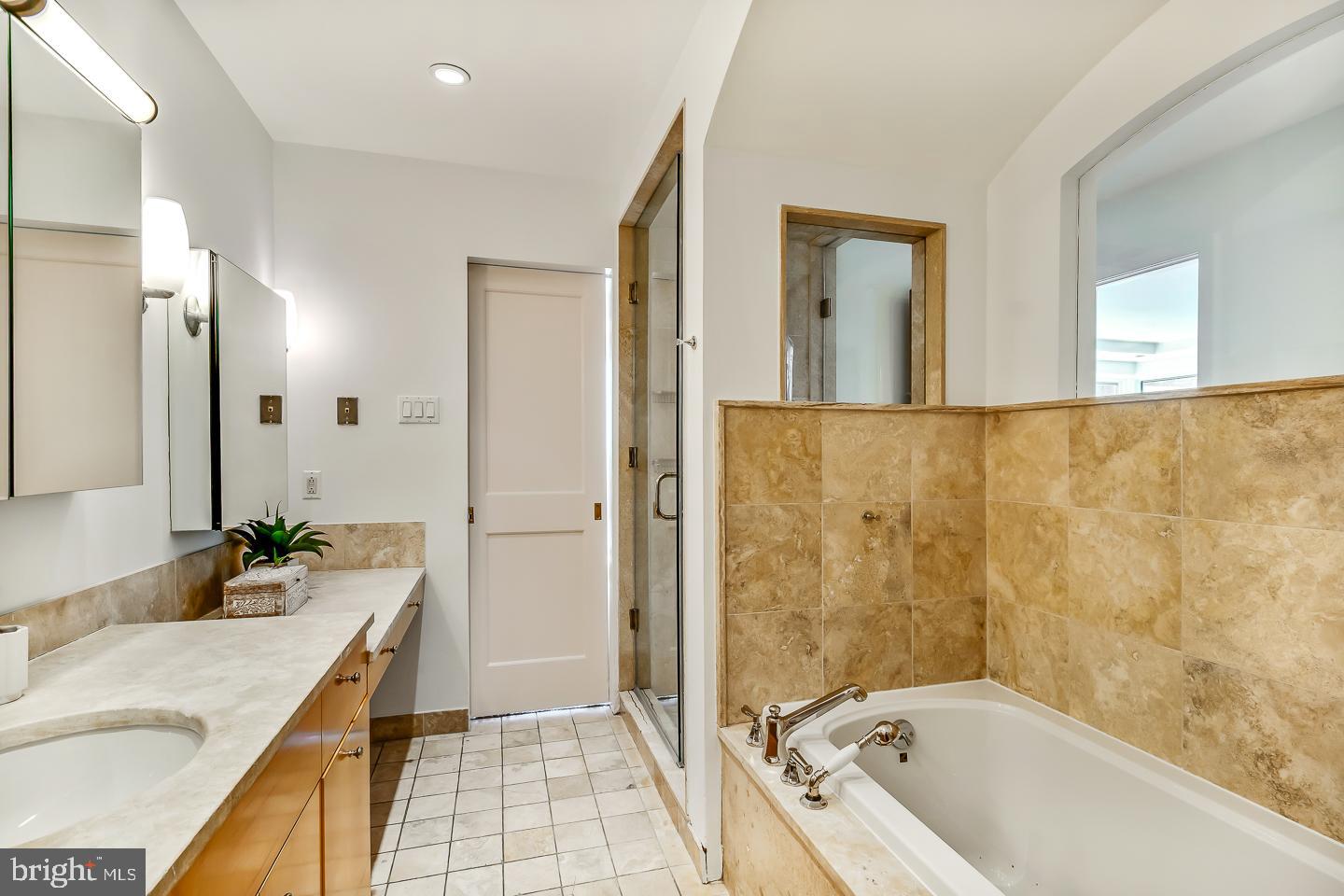 1820 Rittenhouse Square, Unit 1601 Philadelphia, PA 19103 - Photo 41 of 53 a bathroom with a granite countertop tub sink and mirror
