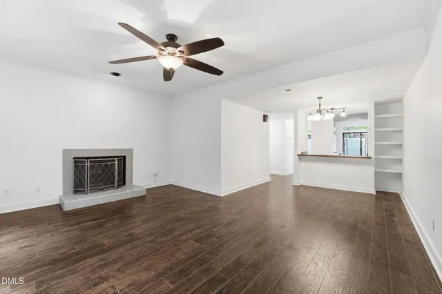 a view of an empty room with window and wooden floor